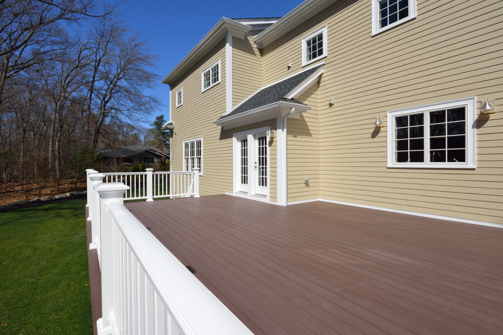 Composite,deck,in,house,backyard.,brown,boards,,white,railing,posts